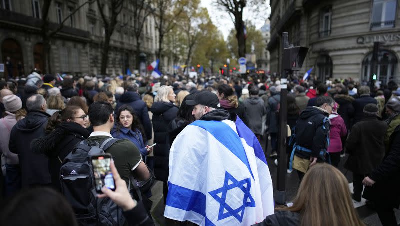 A demonstrator wearing an Israeli flag joins thousands other people for a march against antisemitism in Paris, France, Sunday, Nov. 12, 2023. French authorities have registered more than 1,000 acts against Jews around the country in a month since the conflict in the Middle East began.