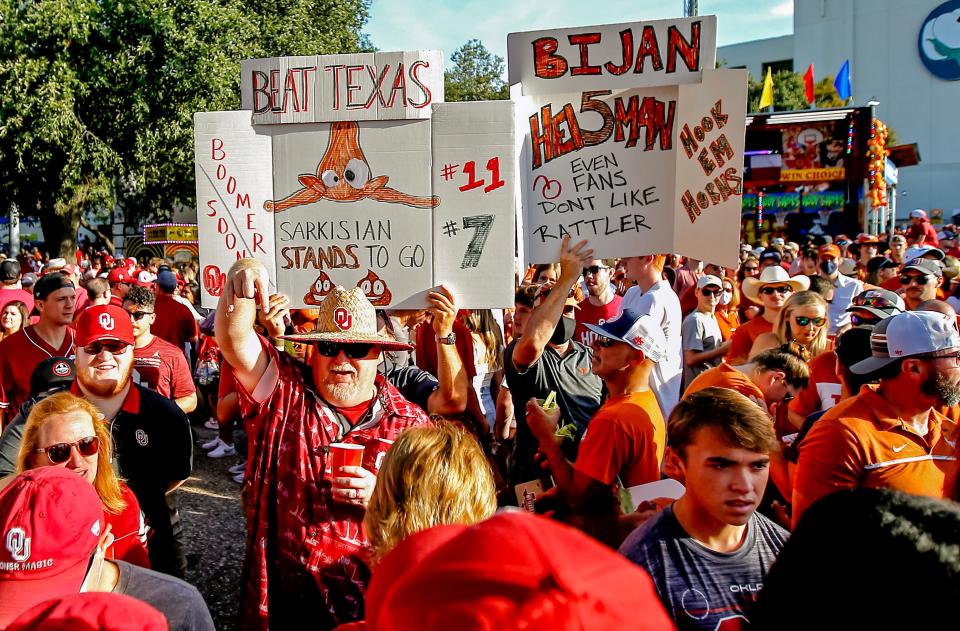 Fans hold signs around the ESPN "College GameDay" set before the Red River Showdown between OU and Texas at the Cotton Bowl in Dallas on Oct. 9, 2021.