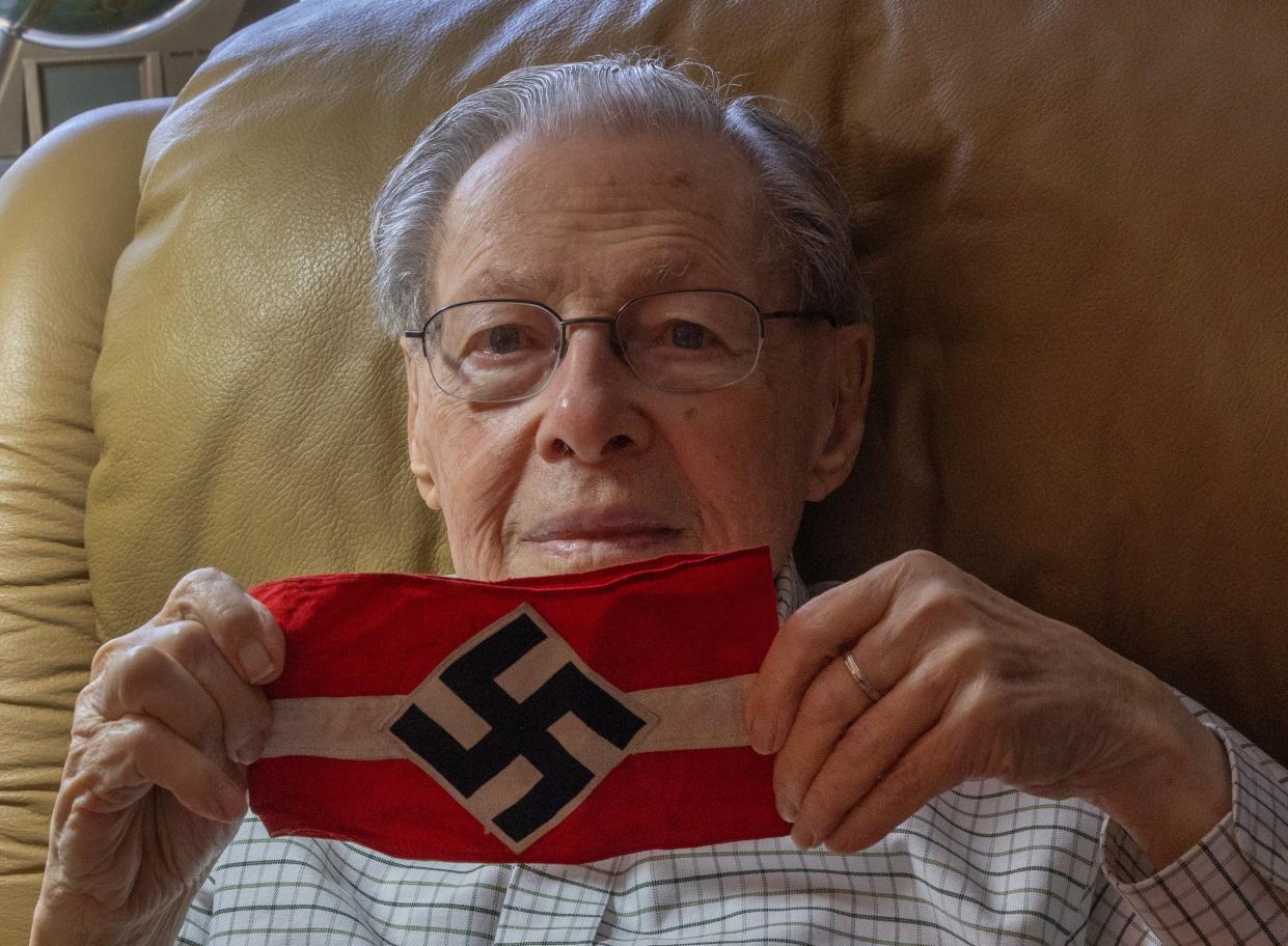 Allan Ostar, a 99-year-old World War II veteran from Tinton Falls, holds a swastika armband that he confiscated. He helped liberate the Dachau death camp.
