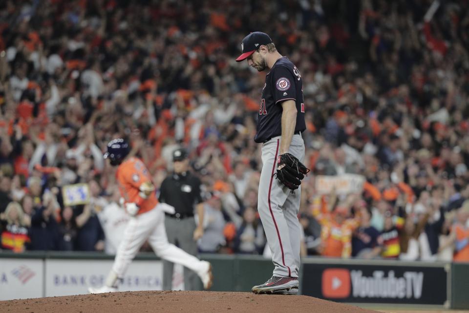 FILE - In this Oct. 30, 2019, file photo, Houston Astros' Yuli Gurriel hits a home run off Washington Nationals starting pitcher Max Scherzer during the second inning of Game 7 of the baseball World Series in Houston. The last time these teams played the Nationals were celebrating their World Series title in Houston. Since then the Astros have become the league's villains, with a sign-stealing scandal tarnishing their reputation and casting a shadow on their 2017 title. (AP Photo/David J. Phillip, File)