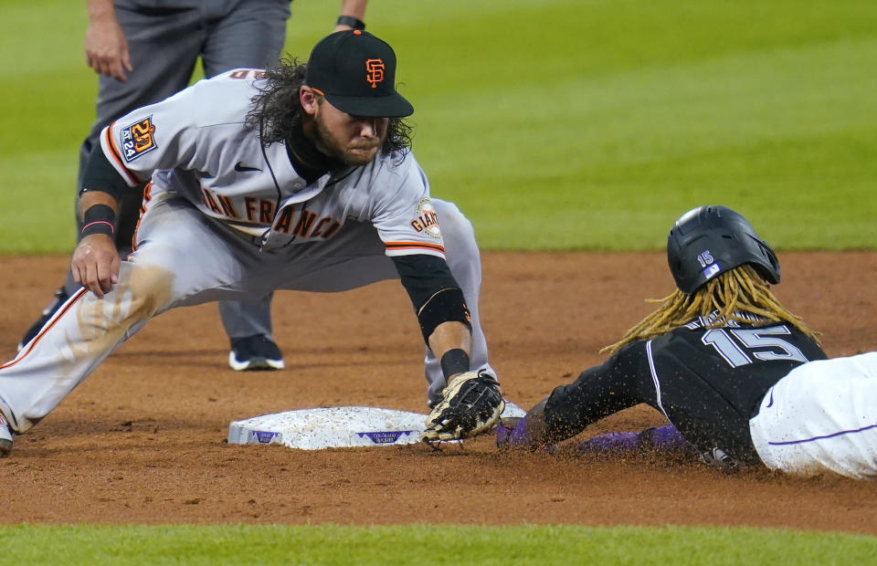 San Francisco Giants shortstop Brandon Crawford (35) tags out Colorado Rockies' Raimel Tapia (15) on an attempted steel during the fifth inning of a baseball game, Wednesday, Aug. 5, 2020, in Denver. (AP Photo/Jack Dempsey)