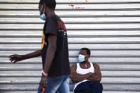 Sudanese migrant sits outside a closed shop in south Tel Aviv, Israel, Sunday, Oct. 25, 2020. After Israel and Sudan agreed this month to normalize ties, some 6,000 Sudanese migrants in Israel are again fearing for their fate. Israel has long grappled with how to deal with its tens of thousands of African migrants. (AP Photo/Oded Balilty)