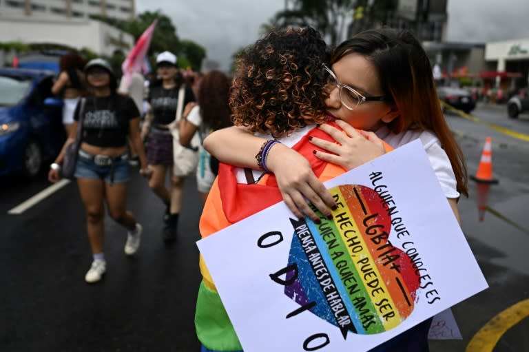 Fiorella Turchkeim (I) y Andrea Ordoñez se abrazan en la Marcha del Orgullo en San Salvador el 29 de junio de 2024. (Marvin RECINOS)