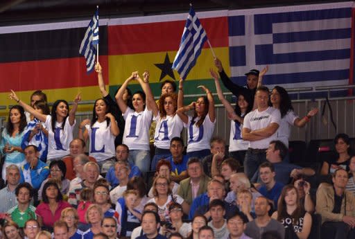 Fans of Greece's Ilias Iliadis cheer during the men's -90kg judo contest of the London 2012 Olympic Games at the ExCel arena in London. Eight years after hosting the Olympic Games in the country where they were born, Greeks seem more interested in finding out if there will be light at the end of their dismal economic tunnel than showing concern about what is happening at the London Olympics