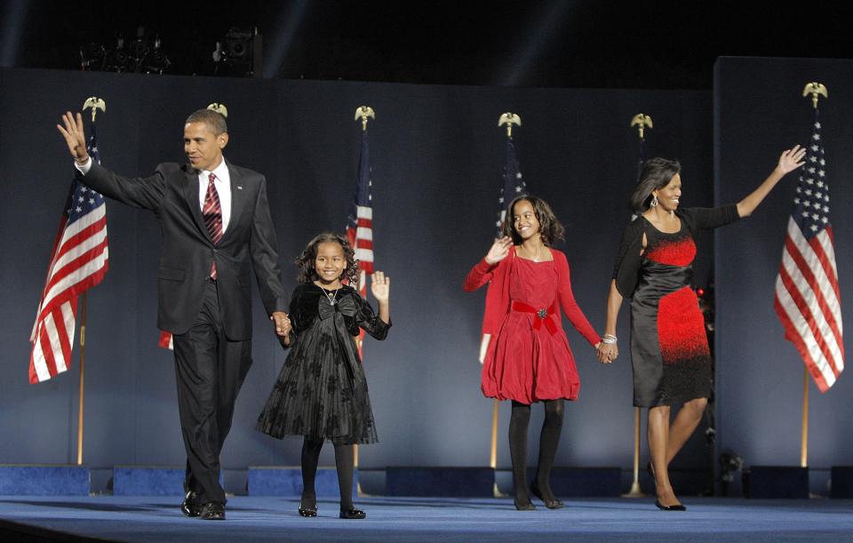 FILE - In this Nov. 4, 2008, file photo, then-President-elect Barack Obama, left, his wife Michelle Obama, right, and daughters, Malia, and Sasha, second from left, wave to the crowd at the election night rally in Chicago. (AP Photo/Jae C. Hong)