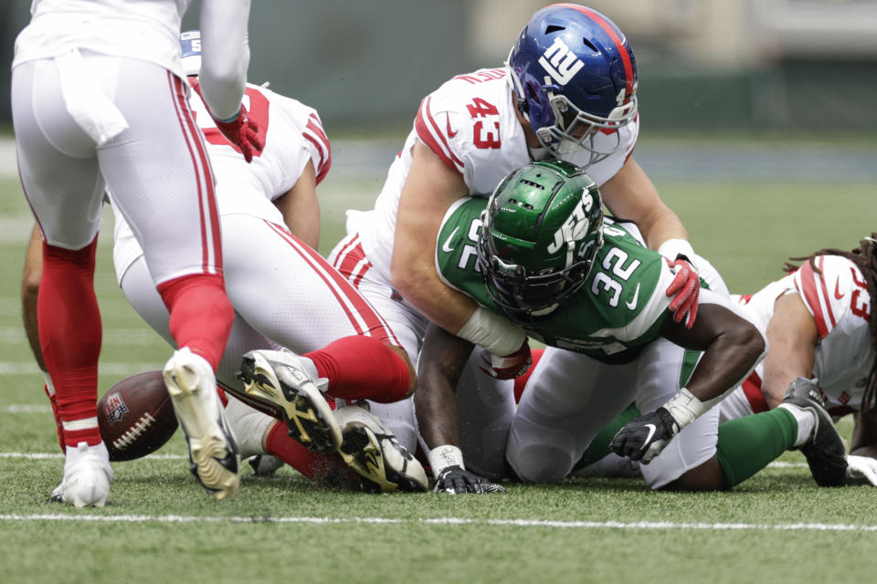 New York Jets running back Michael Carter (32) fumbles the ball before New York Giants linebacker Austin Calitro (59) recovers for a turnover in the first half of a preseason NFL football game, Sunday, Aug. 28, 2022, in East Rutherford, N.J. (AP Photo/Adam Hunger)