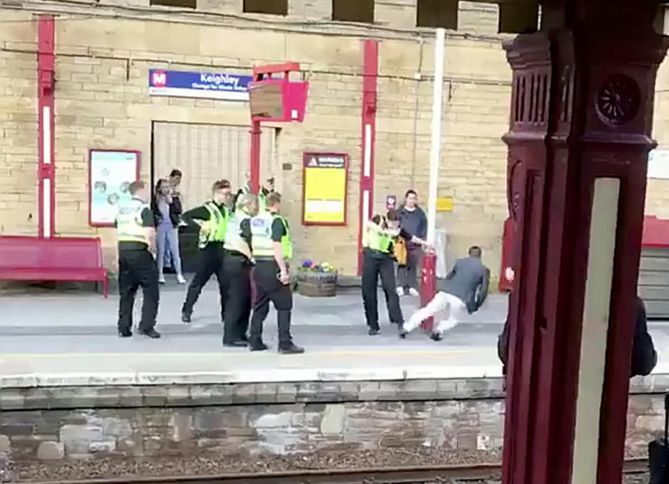 <em>The footage shows police surrounding the man before firing the taser (Picture: SWNS)</em>