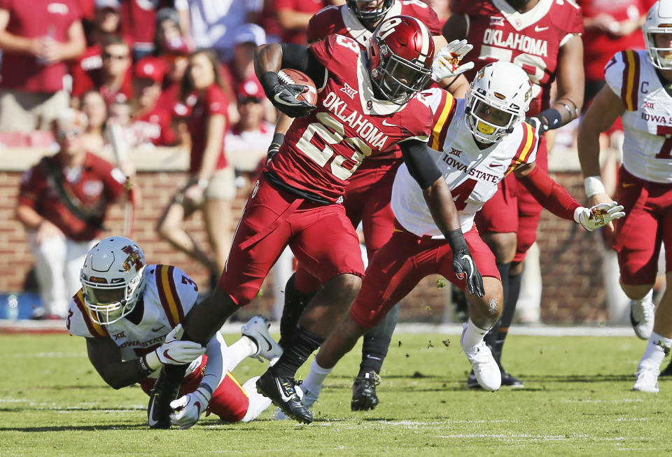 Oklahoma running back Abdul Adams (23) evades a tackle by Iowa State defensive back Reggie Wilkerson (3) during an NCAA college football game in Norman, Okla., Saturday, Oct. 7, 2017. (AP Photo/Sue Ogrocki)