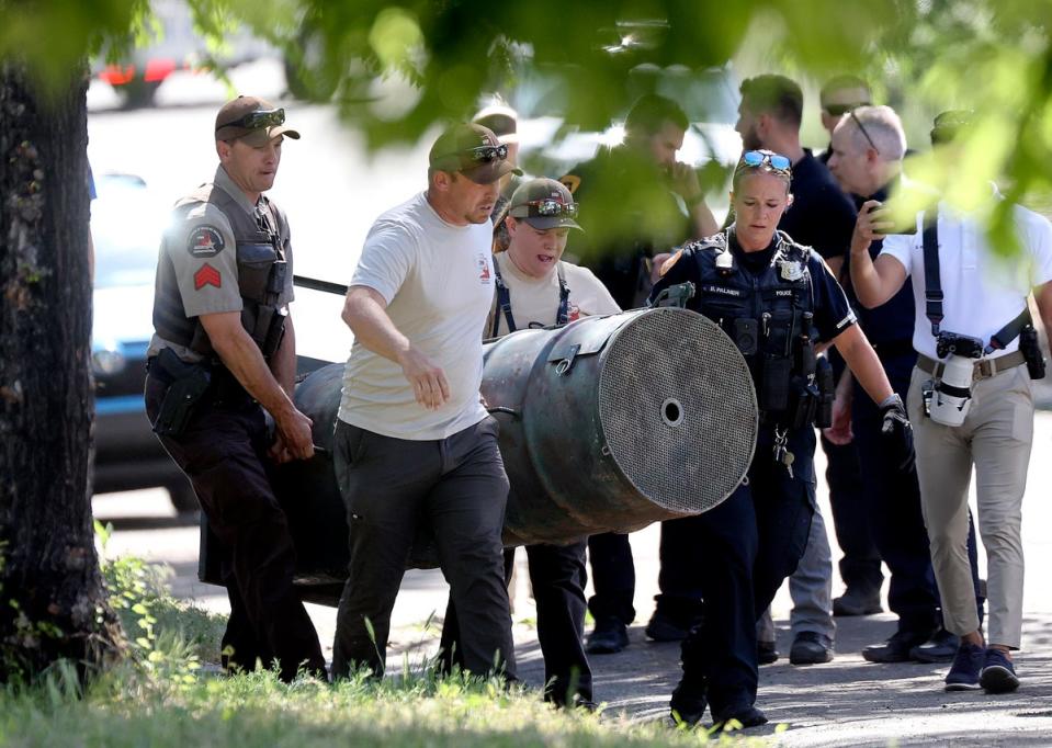 Officials carry the trapped black bear (AP)