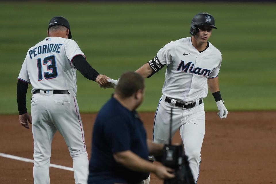 Miami Marlins' JJ Bleday shakes hands with third base coach Al Pedrique (13) after hitting a solo home run during second inning of a baseball game against the San Diego Padres, Monday, Aug. 15, 2022, in Miami. (AP Photo/Marta Lavandier)