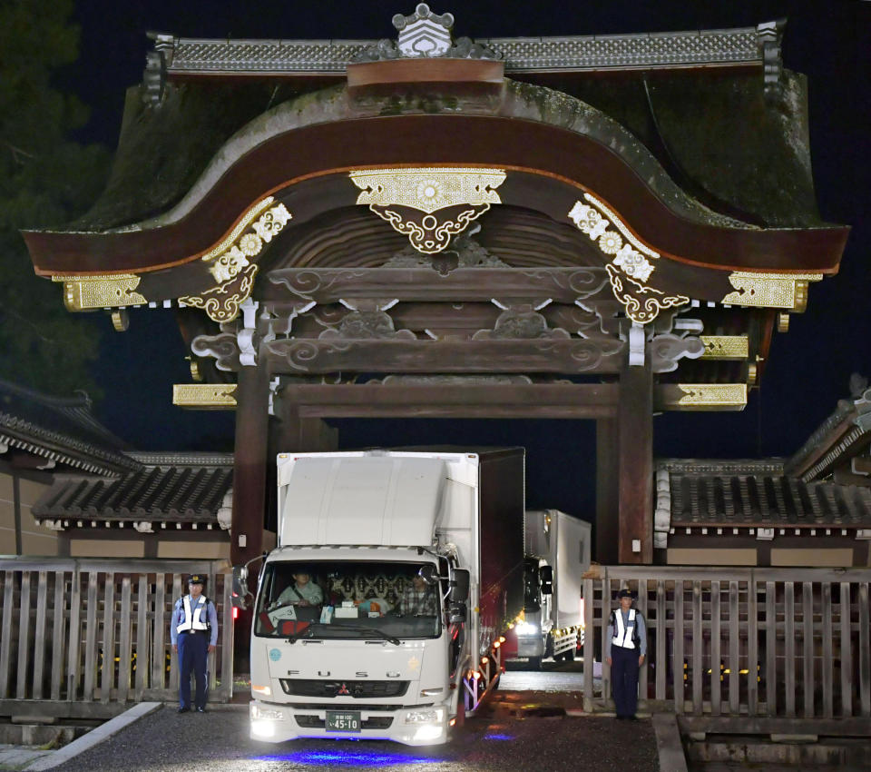 In this late Tuesday, Sept. 25, 2018, photo, trucks carrying parts of Takamikura throne leave a gate of the Kyoto Imperial Palace in Kyoto, western Japan, for the Imperial Palace in Tokyo. The special imperial throne for the coronation of Japan’s new emperor arrived in Tokyo Wednesday, Sept. 26, 2018, from the ancient imperial palace more than a year ahead of time. The Takamikura throne will be used at a ceremony in October 2019 when Crown Prince Naruhito formally announces his succession. (Kyodo News via AP)