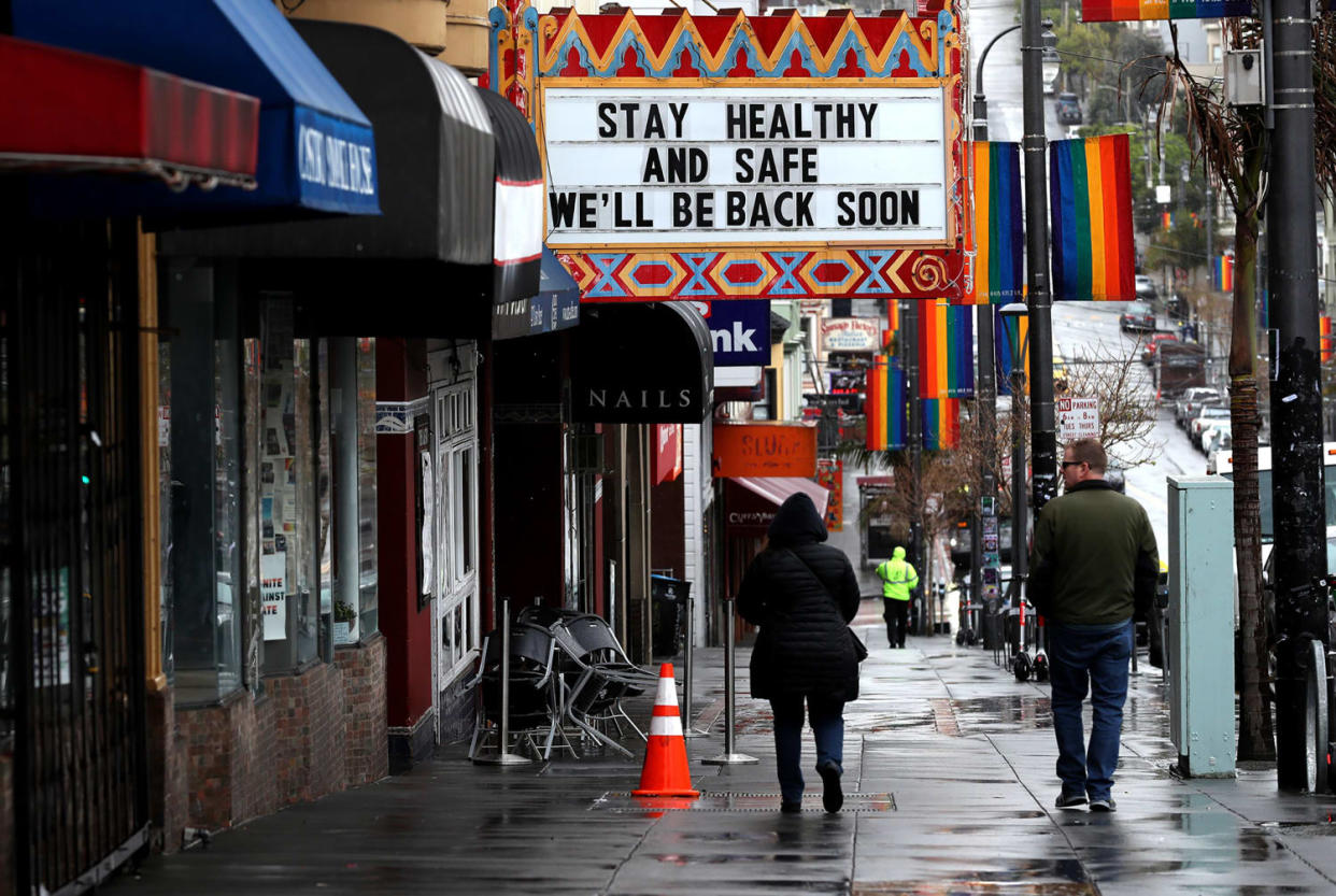 Image: Pedestrians walk by the Castro Theatre in San Francisco (Justin Sullivan / Getty Images)