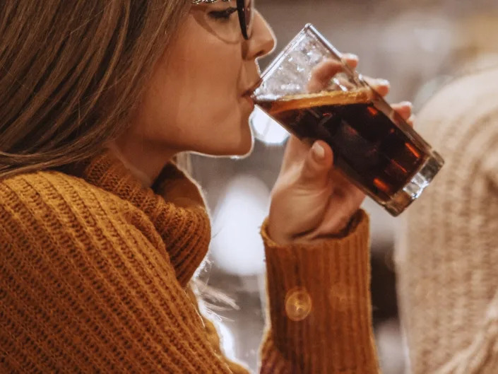 two women drinking soda in a well lit room