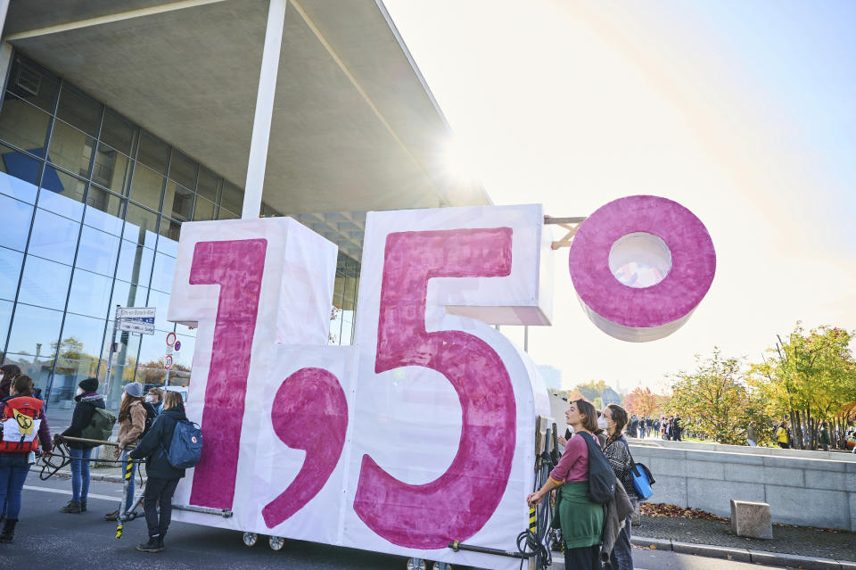 FILE - Demonstrators from Extinction Rebellion push a cart in the shape of the climate target "1.5" in Berlin, Germany on Oct. 24, 2021. That stands for the internationally accepted goal of trying to limit future warming to 1.5 degrees Celsius (2.7 degrees Fahrenheit). (Annette Riedl/dpa via AP, File)