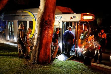 Family and friends of two slain Palm Springs Police Department officers board a bus to join a procession to the county coroner in Palm Springs, California, U.S. October 8, 2016. REUTERS/Sam Mircovich