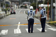 <p>Police officers stand guard at a blocked crossroad near the Tsukui Yamayuri-en, a facility for the handicapped where a number of people were killed and dozens injured in a knife attack in Sagamihara, outside of Tokyo, Japan, Tuesday, July 26, 2016. (AP Photo/Eugene Hoshiko)</p>