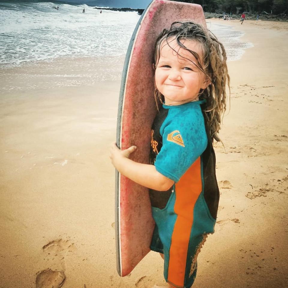 Loretta is seen with her dreadlocks holding a surfboard. Source: Australscope