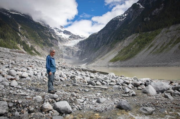 Brian Menounos, a professor of geography at the University of Northern British Columbia, surveys a debris field caused by a landslide off the coast of B.C. in November 2020. (Briar Stewart/CBC News - image credit)