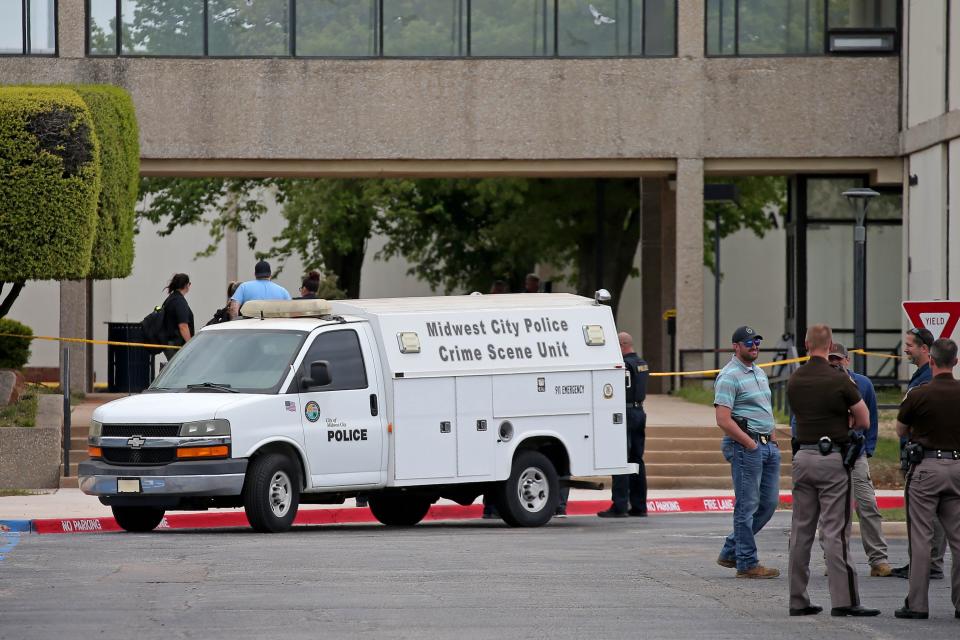 Law enforcement stand outside a building Monday near the scene of a shooting that left one dead on the campus of Rose State College in Midwest City.