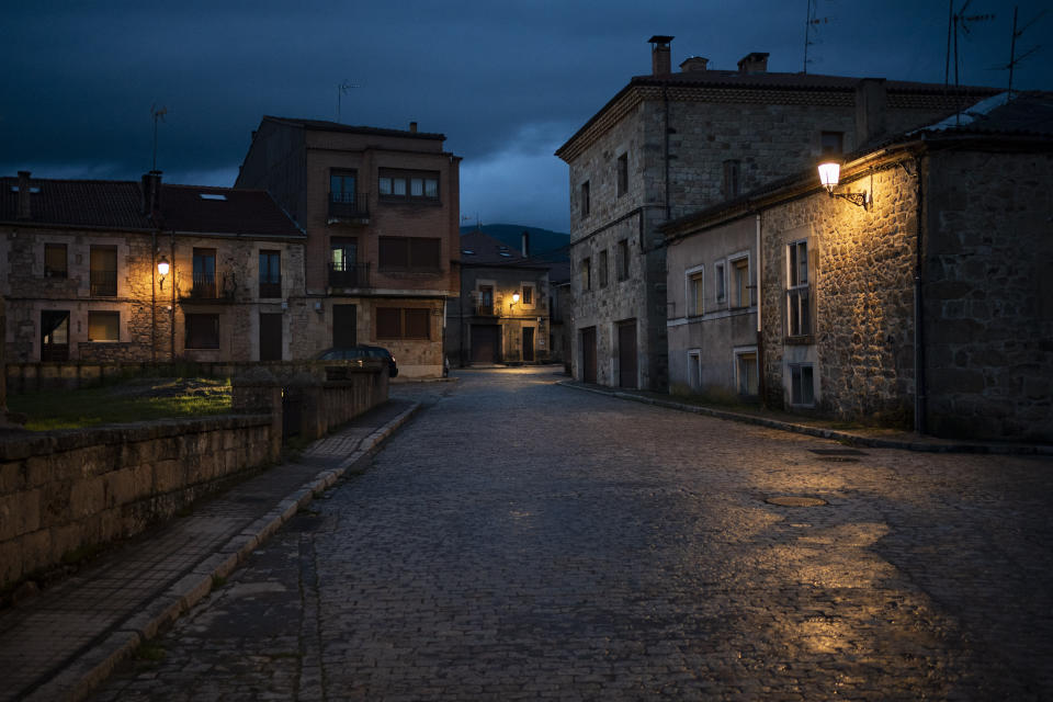 In this April 27, 2020 photo, empty streets are illuminated at dusk in Duruelo de la Sierra, Spain, in the province of Soria. Many in Spain's small and shrinking villages thought their low populations would protect them from the coronavirus pandemic. The opposite appears to have proved true. Soria, a north-central province that's one of the least densely peopled places in Europe, has recorded a shocking death rate. Provincial authorities calculate that at least 500 people have died since the start of the outbreak in April. (AP Photo/Felipe Dana)