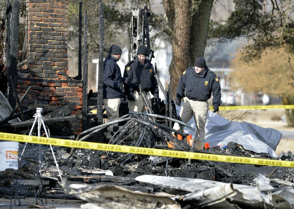 Kentucky State Fire investigators work at the scene of early morning house fire in Depoy, Ky. Thursday Jan. 30, 2014. As many as nine people were killed early Thursday in a house fire in rural western Kentucky and two people were taken to a hospital for treatment, officials said. Eleven people lived in the home in the Depoy community of Muhlenberg County, Greenville Assistant Fire Chief Roger Chandler said. (AP Photo/Timothy D. Easley)