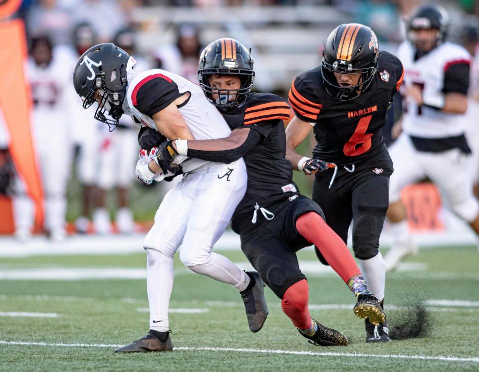 Auburn's Athavion Coleman is tackled by Harlem's DeAndre Young in the season opener at Harlem. Both players are two-way starters and rank 1-2 in the NIC-10 in receiving yards.