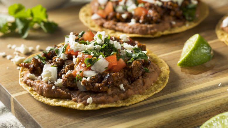 Tostada with toppings on board