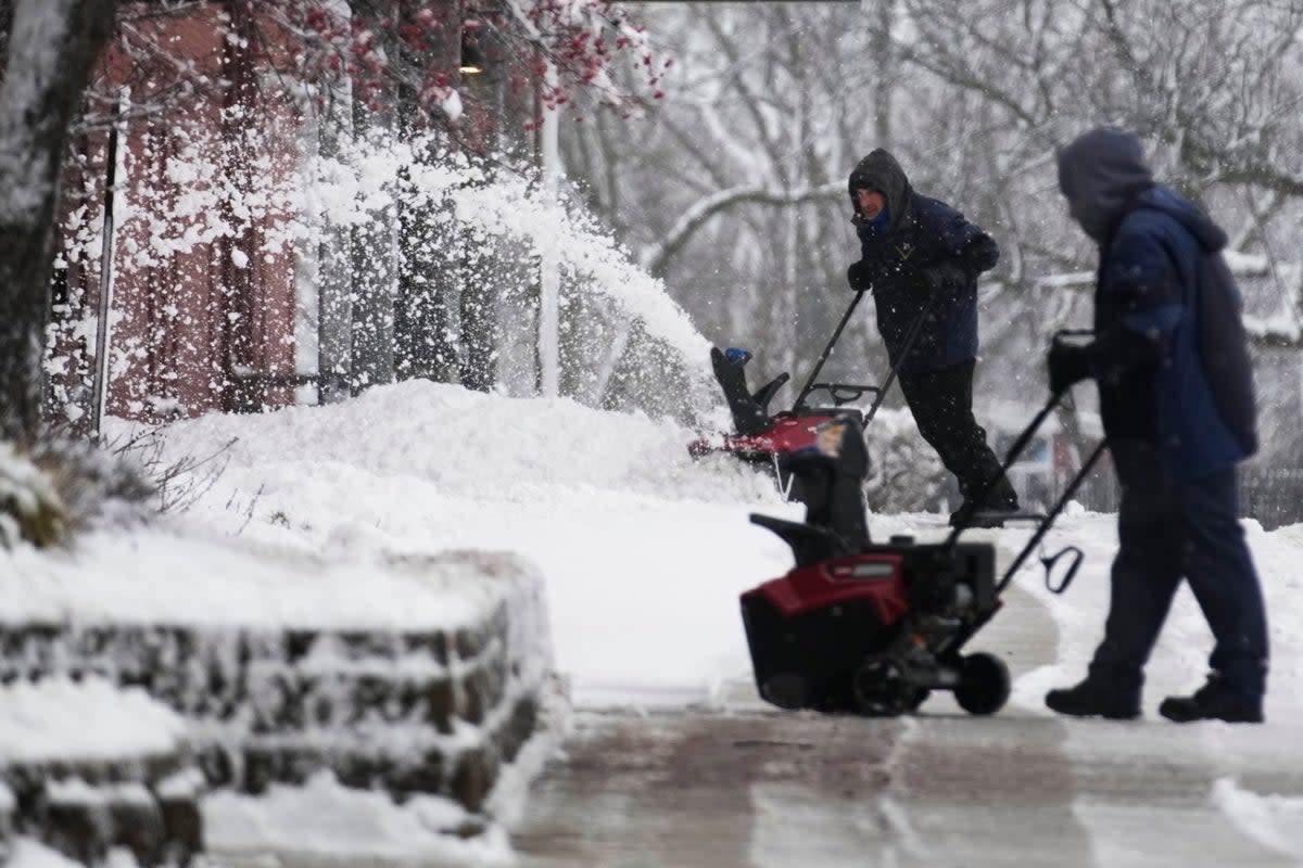 People clean a path from snow in front of a school in Wheeling, Illinois (Copyright 2024 The Associated Press. All rights reserved.)