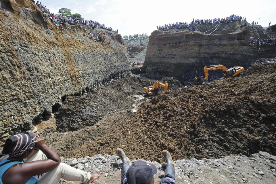 People watch machinery used to dig in search or survivors at a collapsed illegal gold mine in Santander de Quilichao, southern Colombia, Thursday, May 1, 2014. The bodies of three miners have been recovered and an unknown number remain missing, said Temistocles Ortega, governor of the Cauca state. (AP Photo/Oswaldo Paez, El Pais)