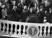 <p>John F Kennedy taking the Oath of Office administered by Chief Justice Earl Warren (left). James Browning, Clerk of the Supreme Court, is centre and Jackie Kennedy is far left.</p>