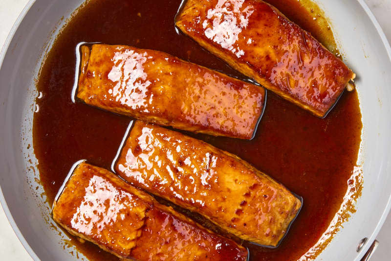 overhead shot of four pieces of harissa orange glazed salmon in a pan.