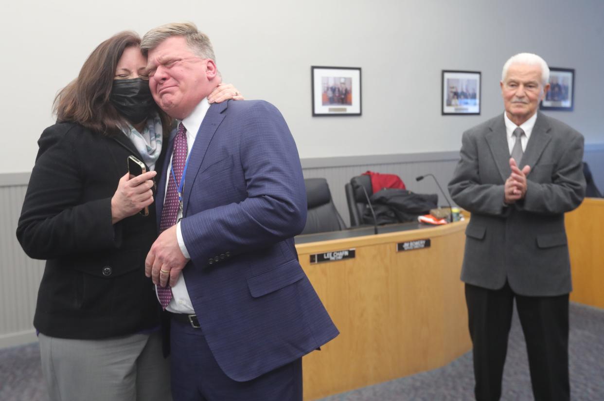 Lisa Armstrong comforts her husband, former Munroe Falls Mayor James Armstrong, as he gives a farewell speech during an oath of office ceremony for new Mayor Allen Mavrides, right, on Jan. 21.