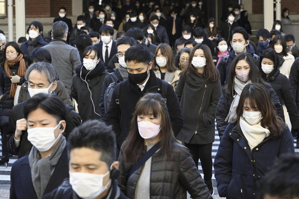 Commuters wear masks outside Tokyo Station in Tokyo Friday, Jan. 20, 2023. Japan's Prime Minister Fumio Kishida on Friday announced plans to start preparations for downgrading legal status of COVID-19 to an equivalent of seasonal influenza in the spring, a move that would further relax mask wearing and other preventive measures as the country seeks an exit plan. (Kyodo News via AP)