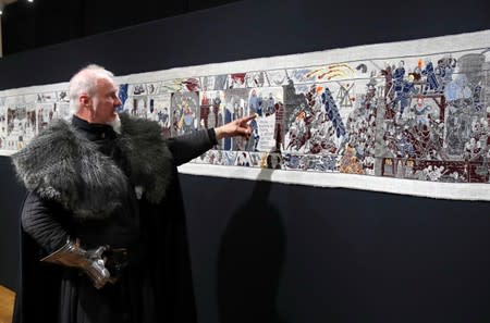 Guide William Van Der Kells of Winterfell Tours points at the Game of Thrones Tapestry in Bayeux