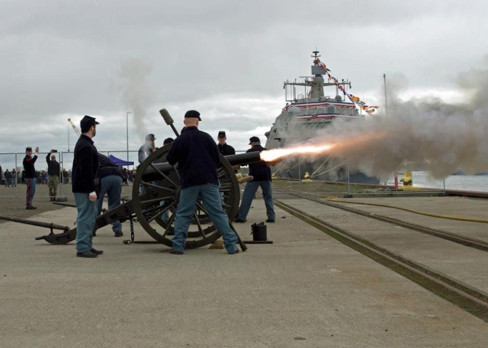 Members of the New Ulm Battery, formed as a town-based militia during the Civil War, fire a cannon at Saturday's commissioning of the USS Minneapolis-Saint Paul in Duluth, Minn.