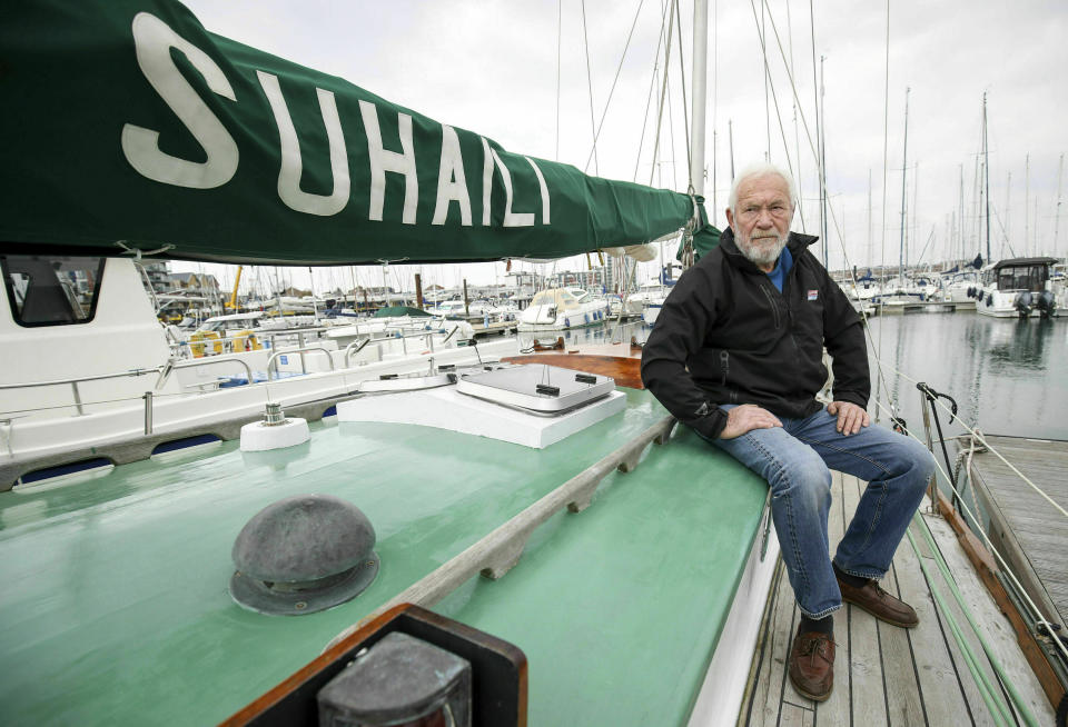 In this Friday, April 12, 2019 photo, Sir Robin Knox-Johnston poses the deck of his boat Suhaili in Gosport, England. Monday, April 22, 2019, commemorates the 50th anniversary of the finish, when Knox-Johnston achieved the nautical equivalent of climbing Mount Everest when he became the first man to sail alone around the world nonstop. (Andrew Matthew/PA via AP)