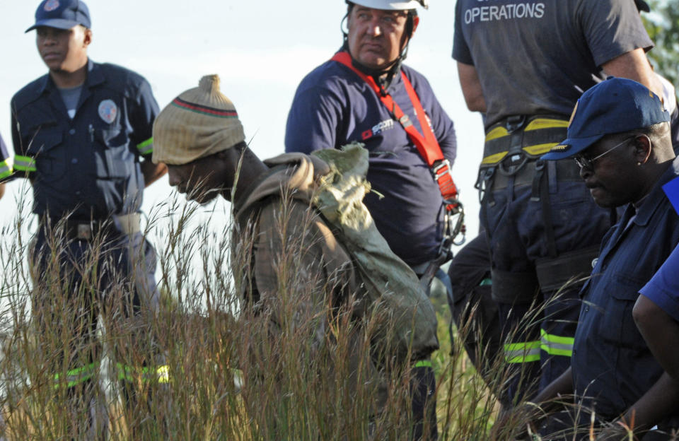 A trapped illegal miner at a disused gold mine shaft near, Benoni, South Africa, is bought to the surface Sunday, Feb. 16, 2014. Debris trapped a group of miners who were working illegally in an abandoned mine in South Africa, but rescue workers cleared the mine shaft entrance and at least 11 miners were escorted to safety Some of the miners still below the surface in the gold mine shaft near Johannesburg appeared to be reluctant to emerge because of fears they would be arrested (AP Photo)