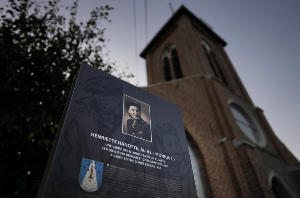 An information board with a photo of Henriette Hanotte stands next to the local church in the center of the town of Bachy, France, Friday, Sept. 16, 2022. Hanotte was a Belgian resistance member during World War II and from the age of nineteen aided the escape of nearly 140 airmen from occupied Belgium into France as part of the Comet Line. (AP Photo/Virginia Mayo)