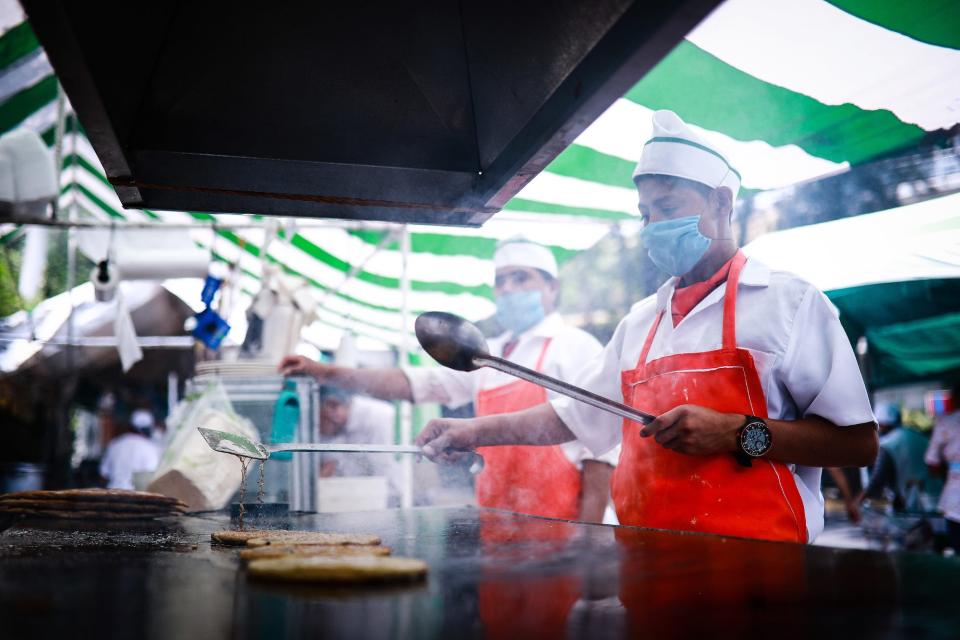 Julio prepares a "gordita de chicharron" in the Antojitos Mexicanos stand at Ometusco street on April 17 in Mexico City. After Government suspended non-essential activities to halt COVID-19 spread, the informal food street industry suffered a drastic reduction of customers, between the 60% and 80%, according the food merchants. Food stalls are allowed to work but take-away only. There is major concern on the impact of the pandemic in Mexico's informal economy, which represents almost 60% of its workforce and 22% of GDP. (Photo by Images)