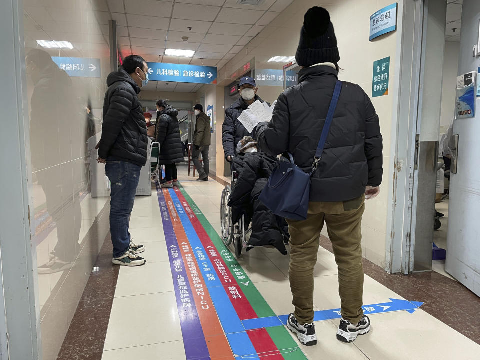 Visitors wait in the emergency department of the Baoding No. 2 Central Hospital in Zhuozhou city in northern China's Hebei province on Wednesday, Dec. 21, 2022. China only counts deaths from pneumonia or respiratory failure in its official COVID-19 death toll, a Chinese health official said, in a narrow definition that limits the number of deaths reported, as an outbreak of the virus surges following the easing of pandemic-related restrictions. (AP Photo)