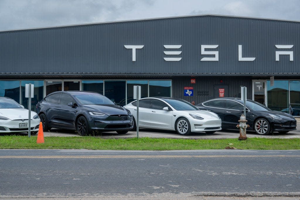 Tesla vehicles sitting on the lot at a Tesla dealership.