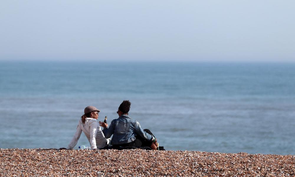 People enjoy the sunshine on the beach in Hastings, East Sussex.