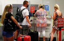 British tourists returning to UK, check in their luggage, as Britain imposed a two-week quarantine on all travellers arriving from Spain