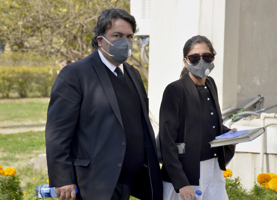 Faisal Siddiqi, left, a lawyer for the family of Daniel Pearl, an American reporter who was kidnapped and killed in Pakistan, arrives with his assistant at the Supreme Court for an appeal hearing in the Daniel Pearl case, in Islamabad, Pakistan, Thursday, Jan. 28, 2021. The court on Thursday has ordered the release of Pakistani man Ahmad Saeed Omar Sheikh convicted and later acquitted in the gruesome beheading of American journalist Pearl in 2002. The court also dismissed an appeal of Sheikh's acquittal by Pearl's family. (AP Photo/Waseem Khan)