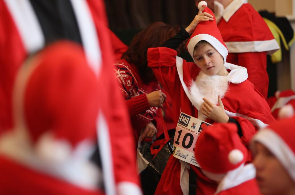 MICHENDORF, GERMANY - DECEMBER 09: Participants dress as Santa Claus in a local community hall shortly before the 4th annual Michendorf Santa Run (Michendorfer Nikolauslauf) on December 9, 2012 in Michendorf, Germany. Over 800 people took part in this year's races that included children's and adults' races. (Photo by Sean Gallup/Getty Images)