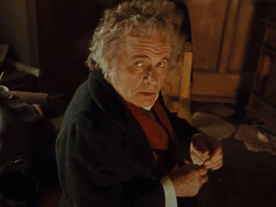 bilbo baggins wearing a black jacket and red scarf in lord of the rings