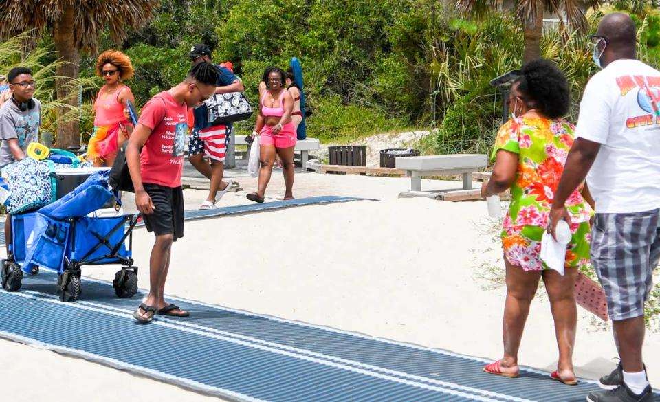 Few beach goers wore face coverings when making their way on and off Hilton Head Island’s beach on Saturday, June 27, 2020 on the narrow pathway near Coligny Beach Park.