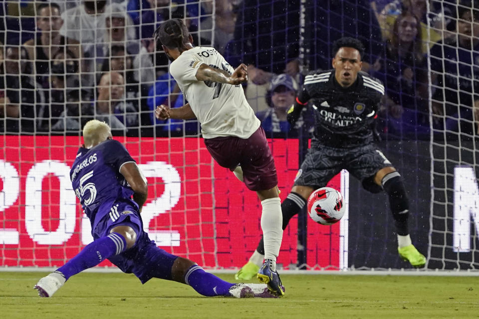 Sacramento Republic's Maalique Foster, center, takes a shot on goal as he gets past Orlando City's Antonio Carlos, left, as goalkeeper Pedro Gallese blocks the shot during the first half of the U.S. Open Cup final soccer match Wednesday, Sept. 7, 2022, in Orlando, Fla. (AP Photo/John Raoux)