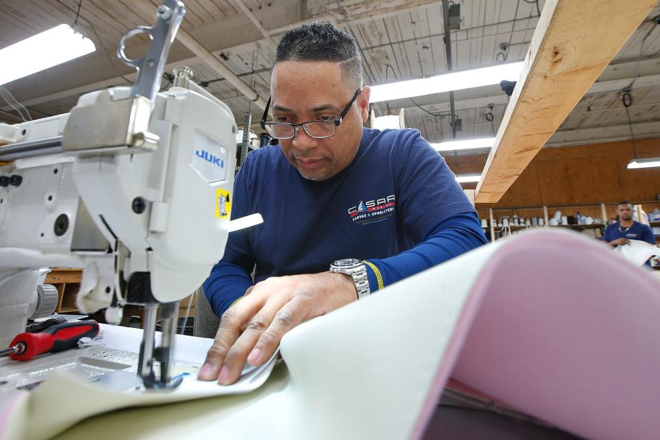 Cesar Abreu stitches upholstery for a boat at Cesar Marine Canvas & Upholstery on Harbor Street in New Bedford.