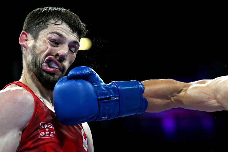 El rostro del canadiense Wyatt Sanford se deforma ante el impacto del uzbeko Ruslan Abdullaev en los cuartos de final de 63,5 kg del boxeo masculino